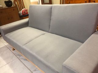 Sofá gris de tela con patas de madera