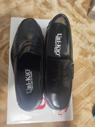 Dos pares de Zapatos Uni-Kio Negros y cafés.