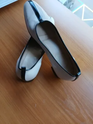Zapatos de piel crema y adornos marron ribeteados