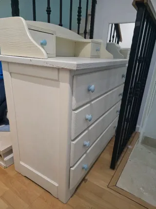 Cómoda de madera con tiradores azules.