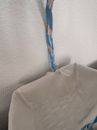 Cesta mimbre blanco, con tela y cinta lazo azul.