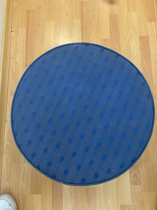 Puff azul de tela con patas de madera