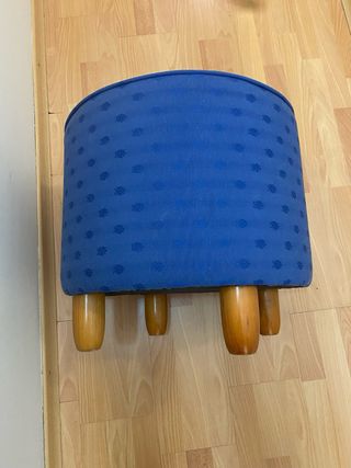 Puff azul de tela con patas de madera