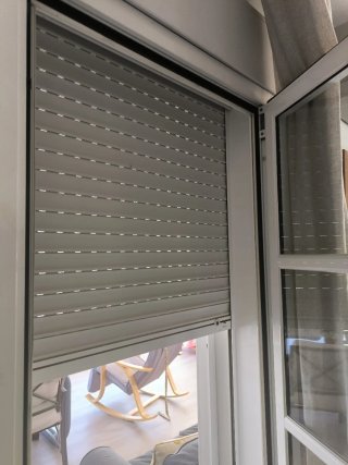 Puerta abatible con palillería, aluminio blanco.