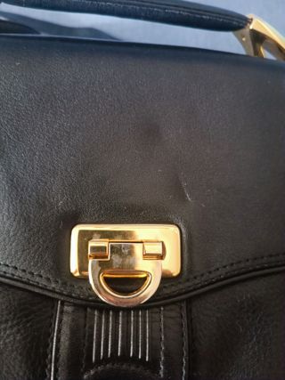 Bolso de piel negro con detalles dorados