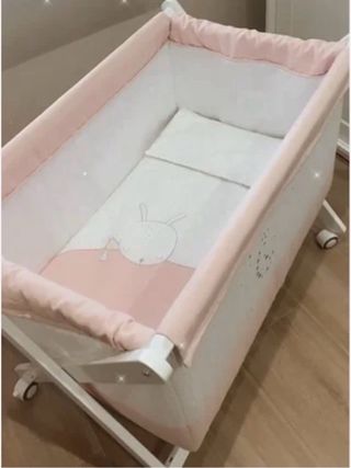 Minicuna rosa y blanca con ruedas