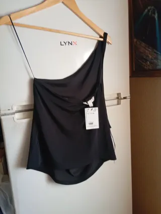 Blusa negra asimétrica con etiqueta