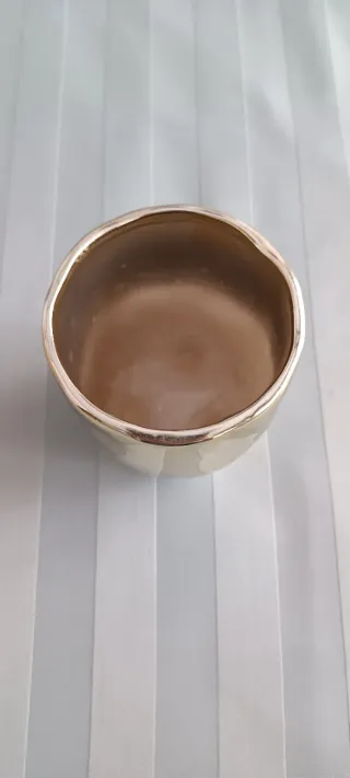 Jarrón metálico dorado.