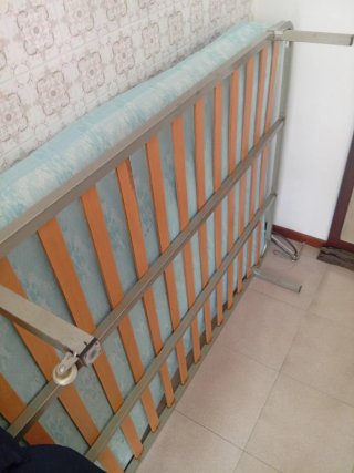 Estructura de cama con somier de madera y colchon.