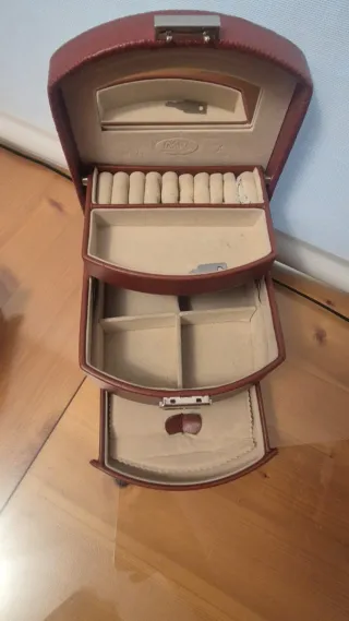Joyero marrón de piel con espejo y cajones.