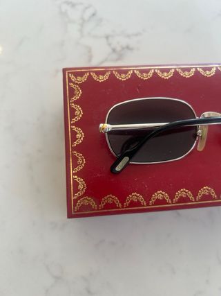 Gafas de sol plateadas y negras con caja
