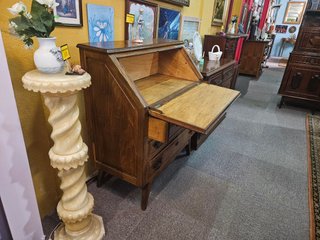 Escrivaninha em madeira com marcas de uso