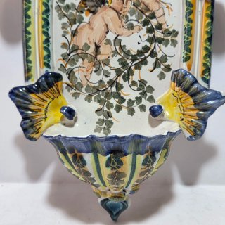 Acquasantiera in maiolica con putti