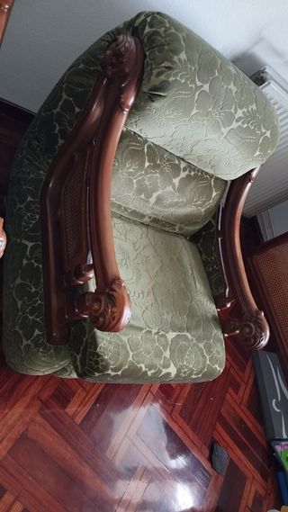 Sofá de terciopelo verde con detalles de madera