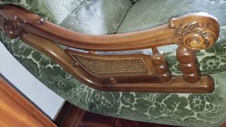 Sofá de terciopelo verde con detalles de madera