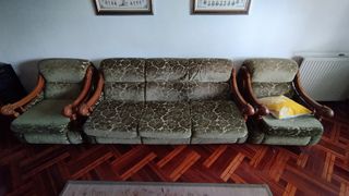 Sofá de terciopelo verde con detalles de madera