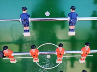 Futbolín con jugadores rojos y azules