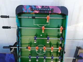 Futbolín con jugadores rojos y azules