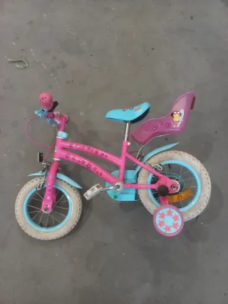Bicicleta infantil rosa y azul con ruedines