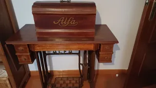 Máquina de coser Alfa antigua en mueble de madera