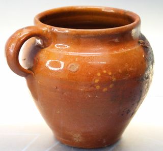 Pequeña y antigua olla de barro.