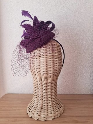 Tocado morado con velo y plumas