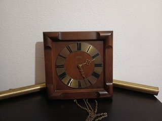 Reloj de madera con péndulo y cadena