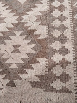 Alfombra beige y marrón geométrica.