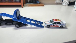 Camión grúa azul con coche de juguete