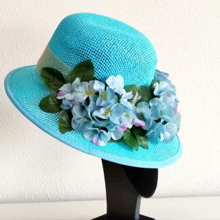 Sombrero turquesa con flores.