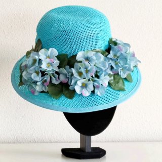 Sombrero turquesa con flores.