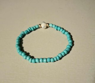 Pulsera turquesa con perla y detalles dorados