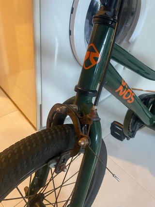 Bicicleta infantil verde con detalles naranjas