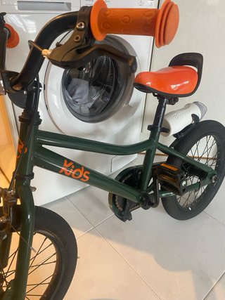 Bicicleta infantil verde con detalles naranjas