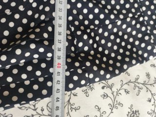 Falda lunares plisada negra con lunares blancos.