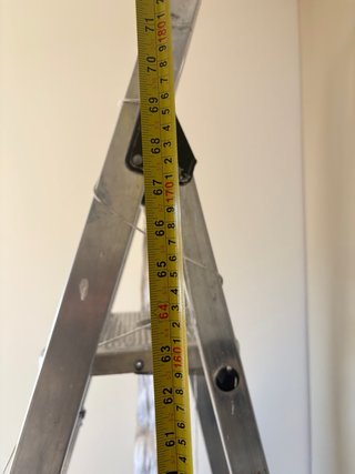 Escalera metálica alta para obras y pintor.