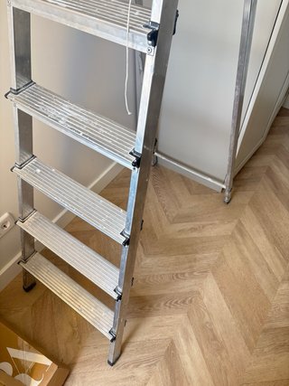 Escalera metálica alta para obras y pintor.