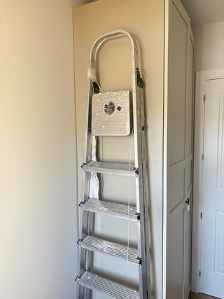 Escalera metálica alta para obras y pintor.