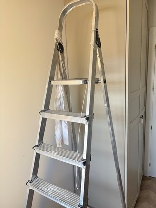 Escalera metálica alta para obras y pintor.