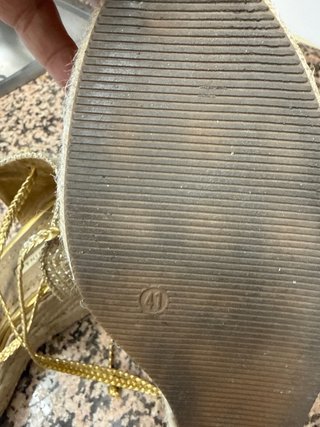 Sandalias doradas Corina cuña atadas al tobillo.