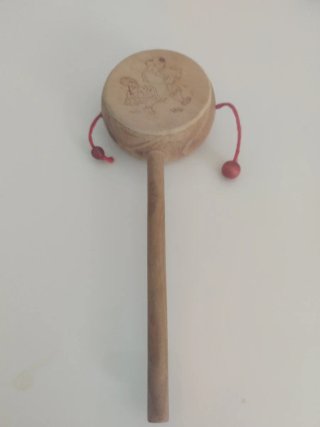 Tambor de madera con cuentas rojas