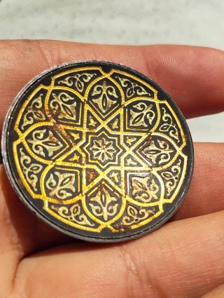 Moneda antigua con diseño geométrico