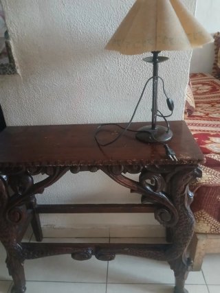 Mesa de madera tallada a mano y lámpara.