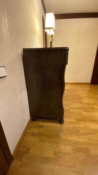 Cajonera de madera oscura con detalles.