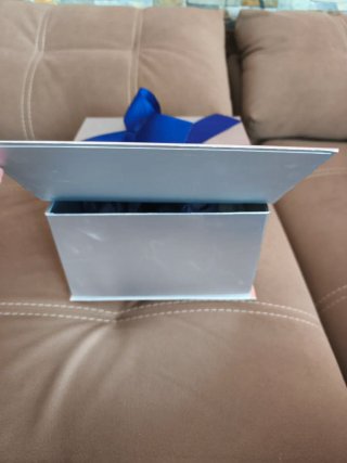 Caja de regalo plateada con lazo azul
