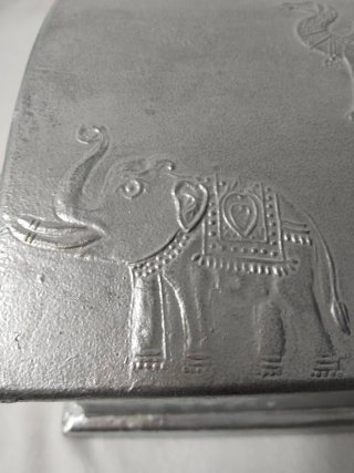 Revistero de metal plateado con elefante mide 25x2