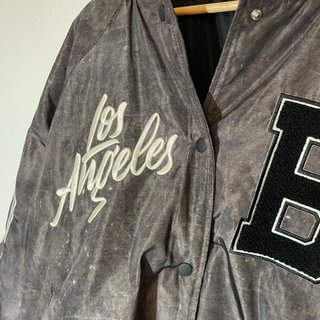 Chaqueta gris y negro estilo baseball.