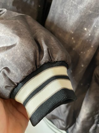 Chaqueta gris y negro estilo baseball.
