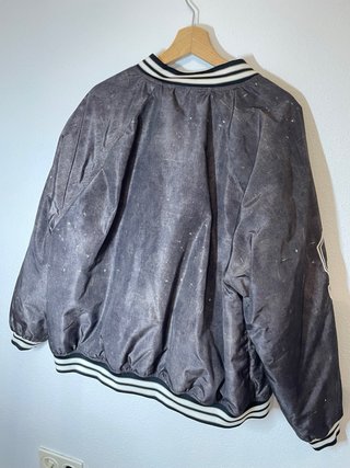 Chaqueta gris y negro estilo baseball.