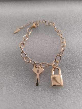 Pulsera dorada con llave y candado